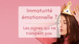 Une femme en pull rose sur fond rose pose une couronne dorée sur sa tête, le syeux fermés et la bouche en cul de poule, illustration de l'immaturité émotionnelle