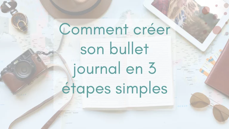Une carte du monde déployée sur un bureau avec au centre un bullet journal entouré d'une boussole, de lunettes, chapeau et photos, pur s'inspirer et créer.