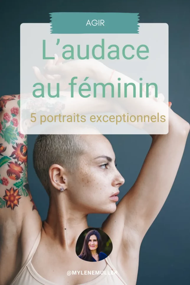 Femme de profil au crâne rasé, bras levés dans un geste affirmé, affichant un regard déterminé. Son bras droit est entièrement couvert de tatouages colorés. Sur un fond bleu intense, elle incarne la force et l’audace au féminin.