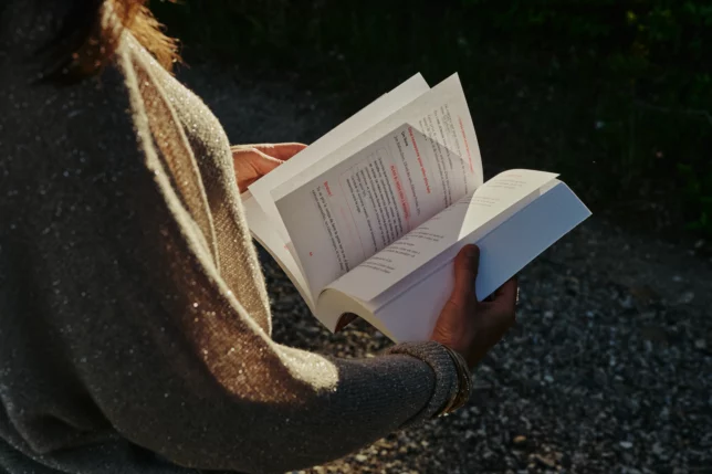 Mylène feuilletant son livre CAP de créer la vie qui te ressemble ? 52 défis pour réenchanter ta vie