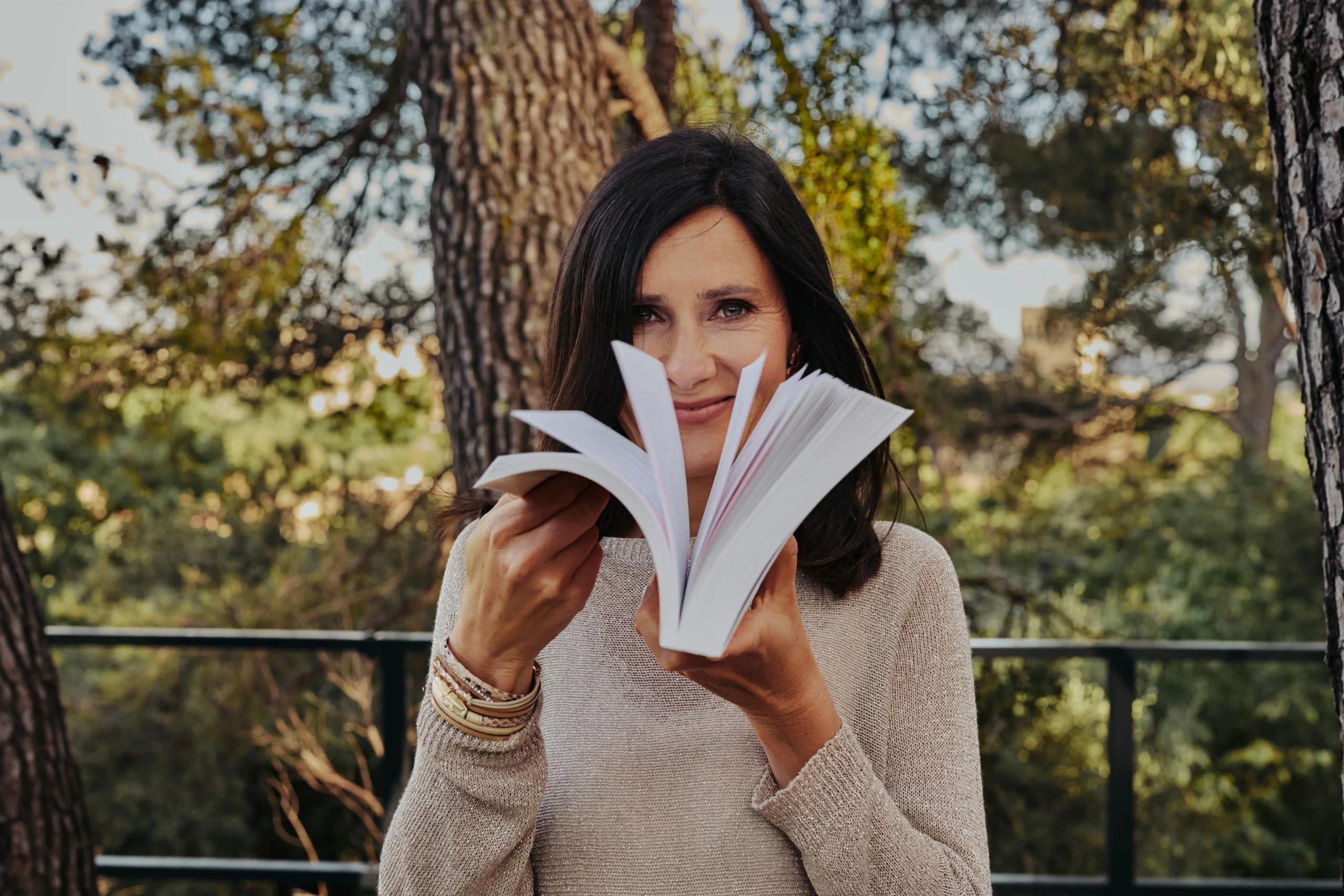 Mylène feuilletant son livre CAP de créer la vie qui te ressemble ? 52 défis pour réenchanter ta vie, avec le sourire