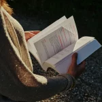 Mylène feuilletant son livre CAP de créer la vie qui te ressemble ? 52 défis pour réenchanter ta vie